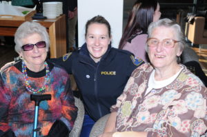 Constable Casey Wood in uniform is pictured with retired officers Mrs Judy Burgess and Mrs Margaret Medwin who are both seated at the High Tea function celebrating 100 years of women in policing with Tasmania Police.