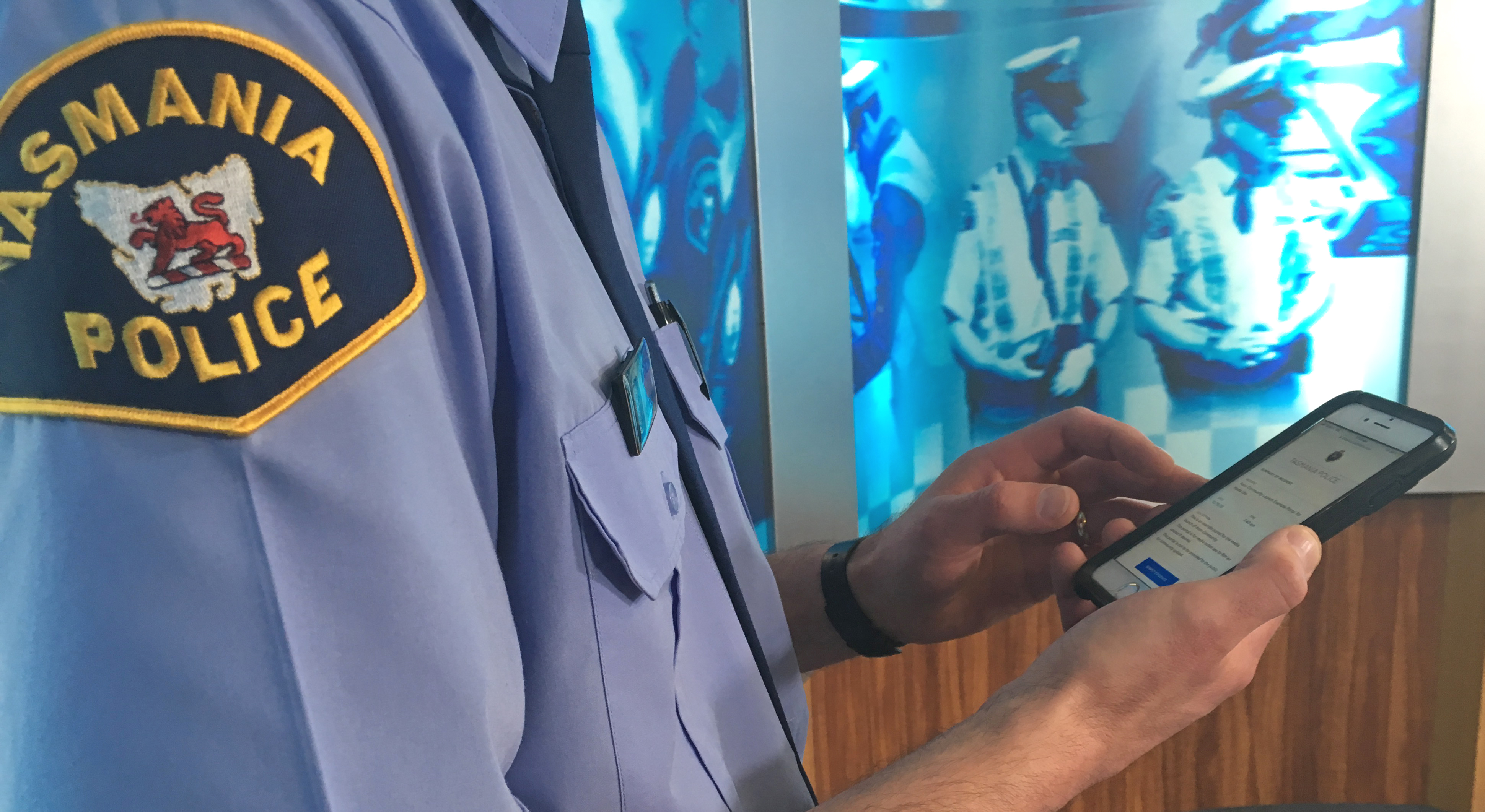 Police officer in uniform accessing Axon Community portal on mobile phone